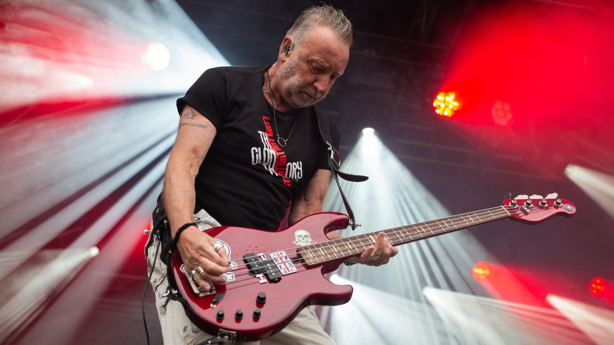 Peter Hook playing bass guitar on stage