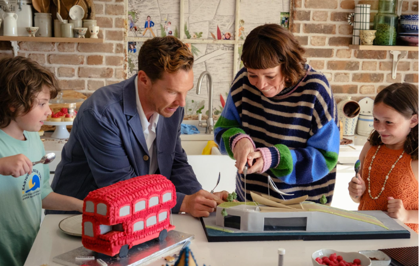 A person and person looking at a model of a building