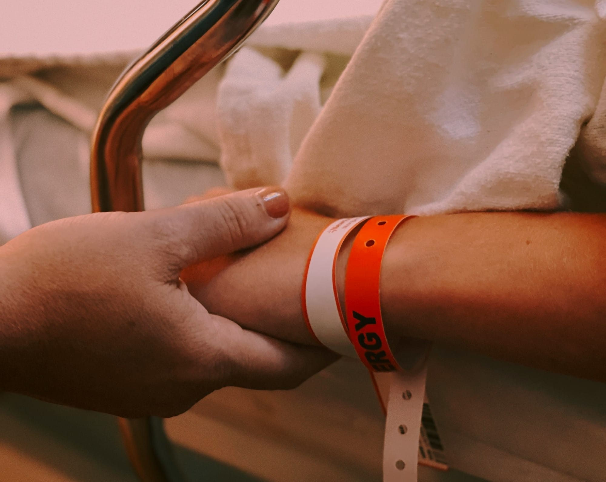 person wearing orange and white silicone band