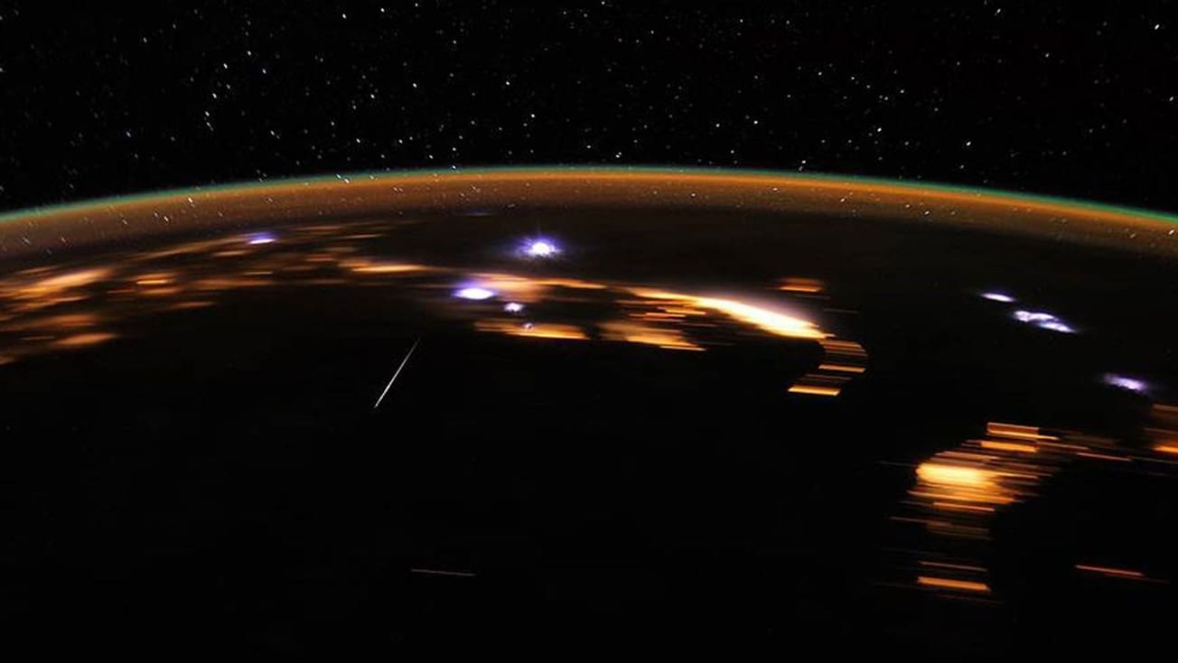 Image taken of Earth from space by NASA astronaut of lyrid meteors crossing over the Earth. The night sky is in the background. 